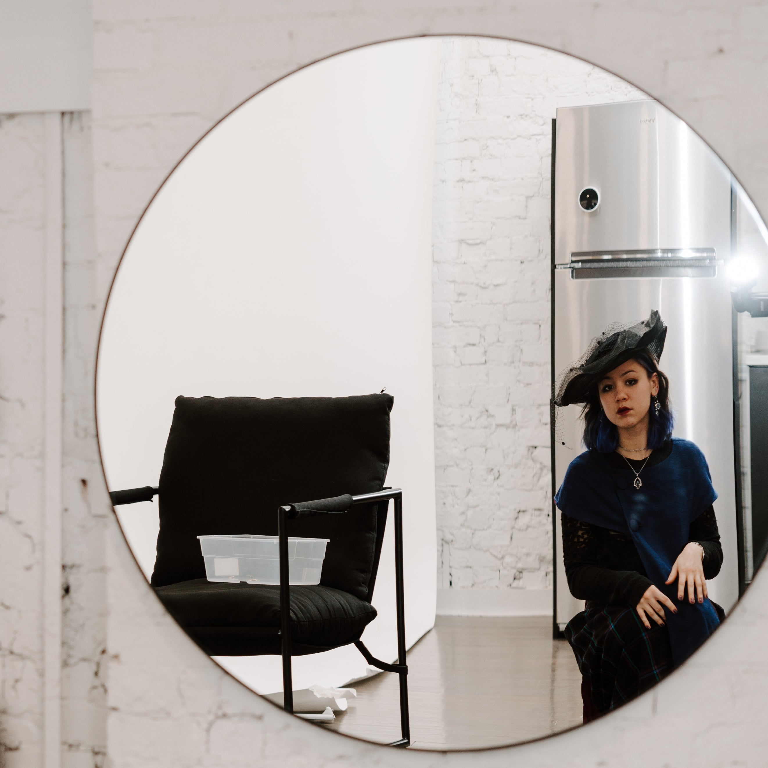 Person wearing a styled outfit and fidget jewelry looking at themselves in a mirror