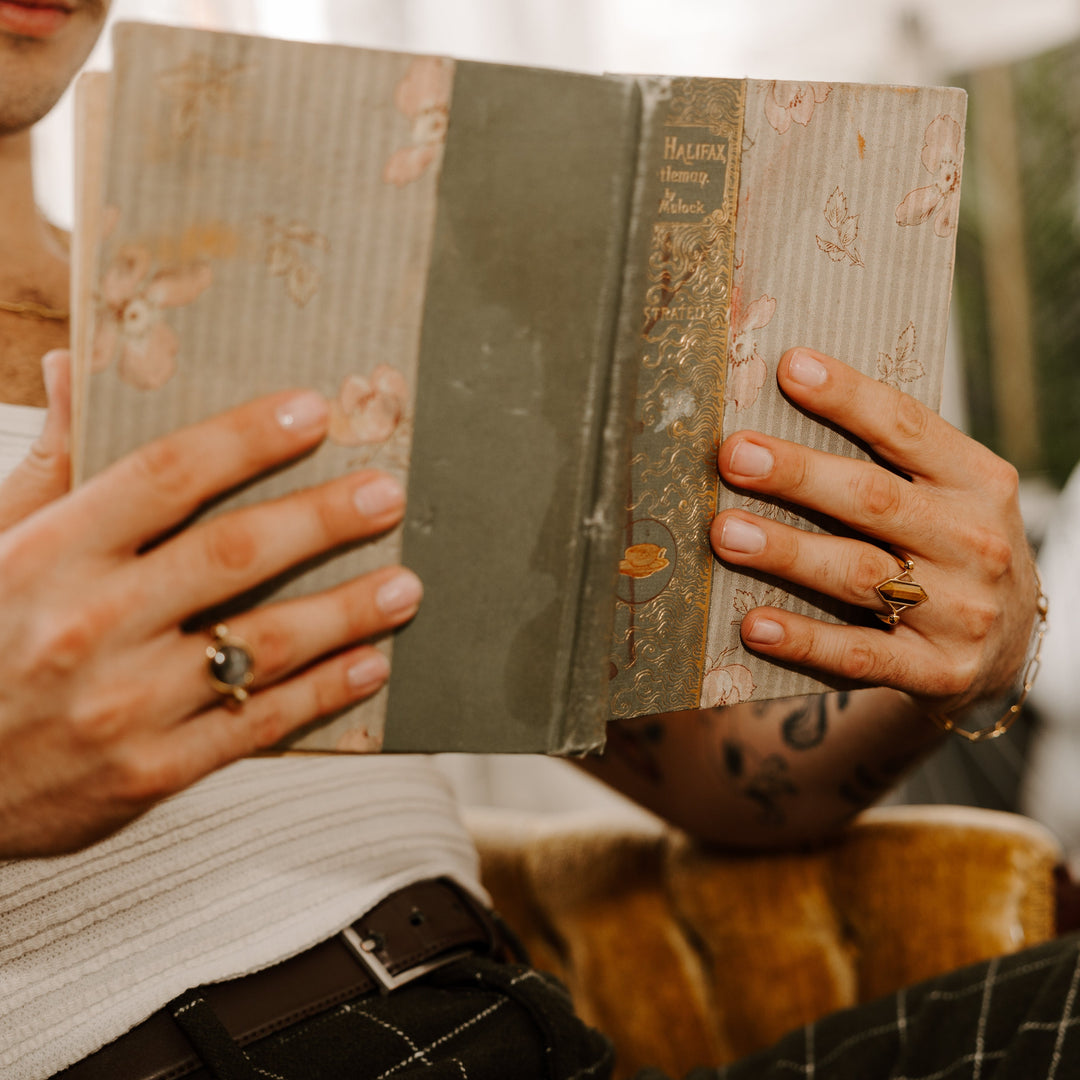 Person reading a book and wearing crystal fidget rings
