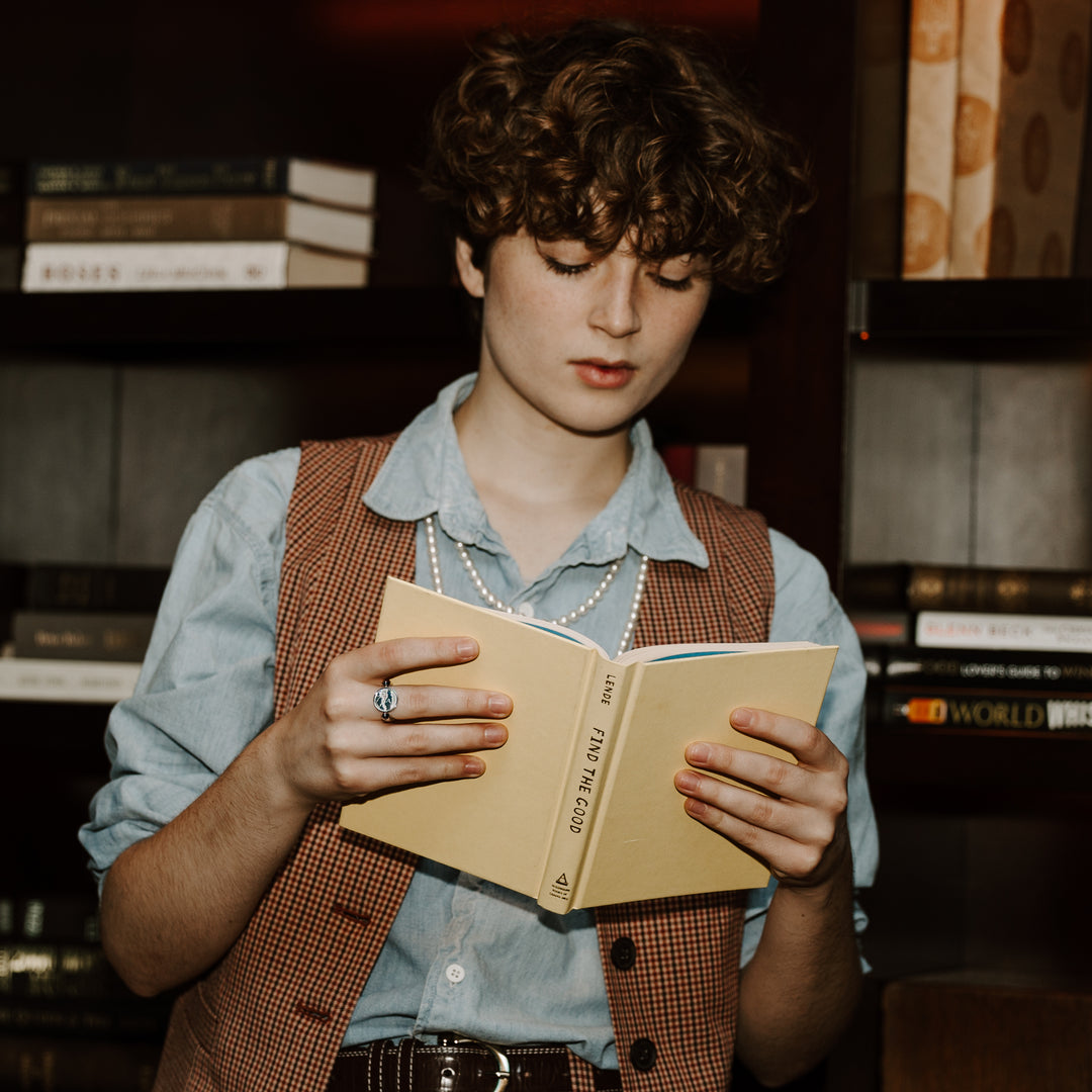 Person reading a book wearing silver fidget ring