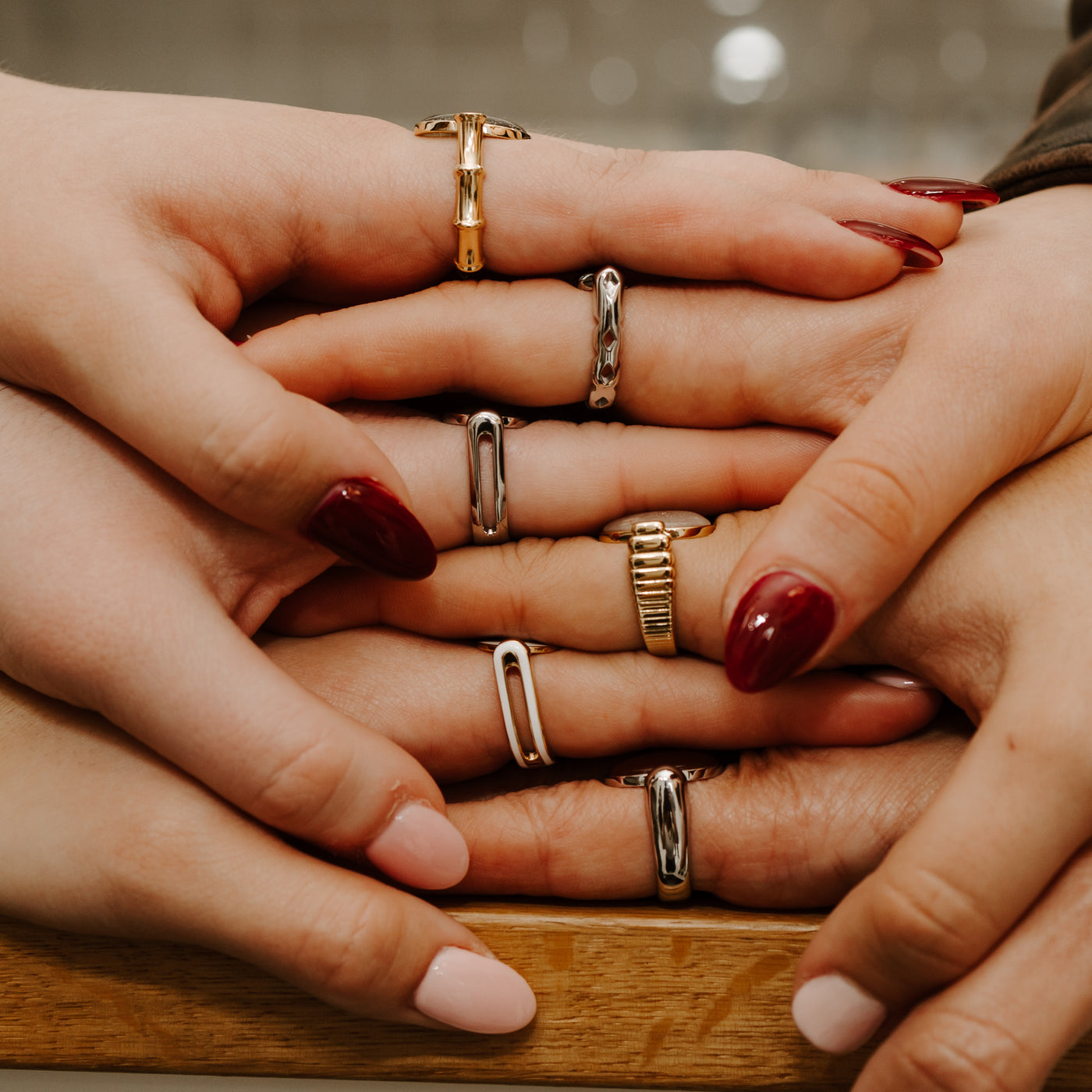 People wearing various metals of fidget rings, stacking their hands on top of each other.