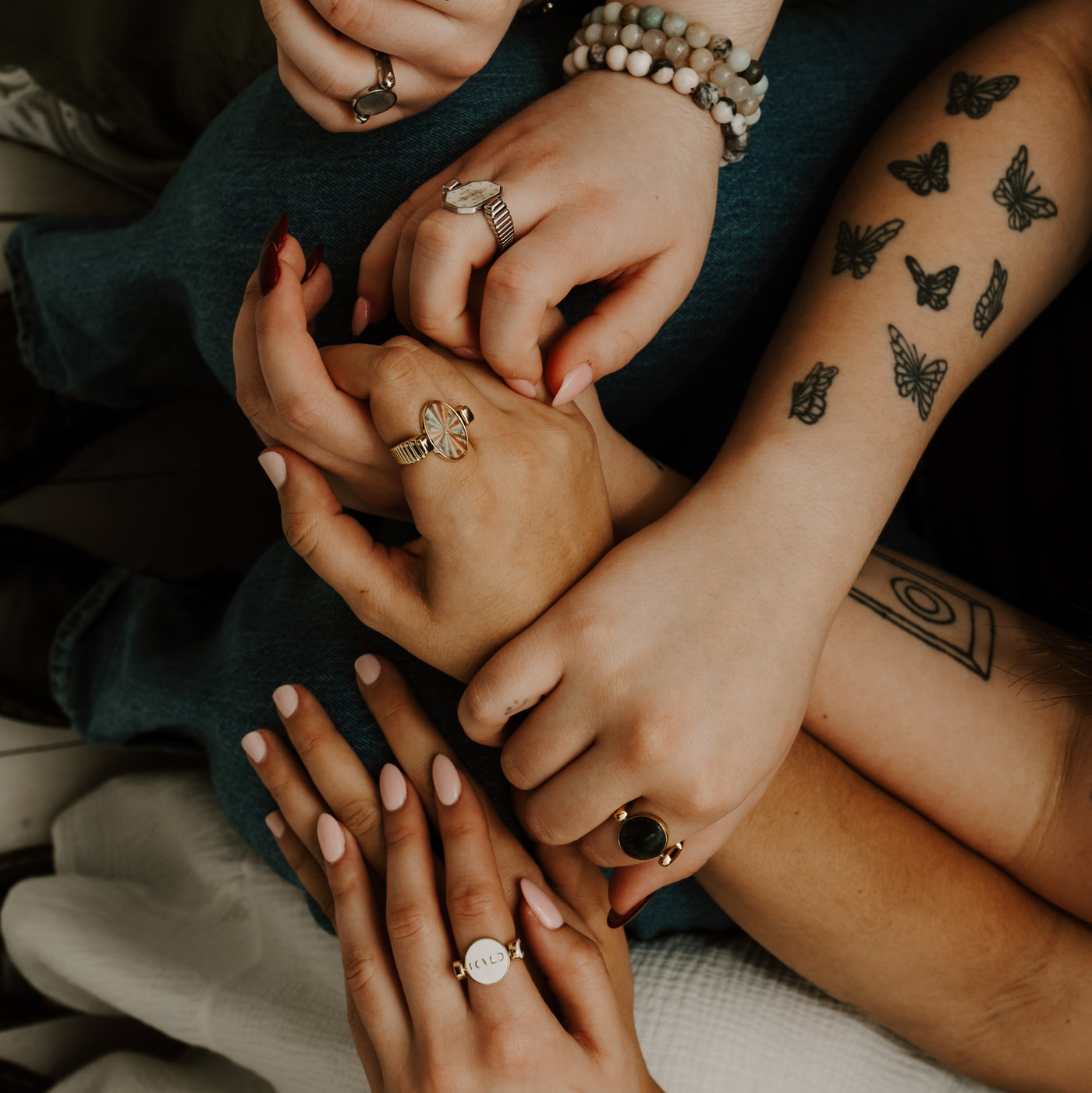 People holding hands wearing various styles of fidget jewelry