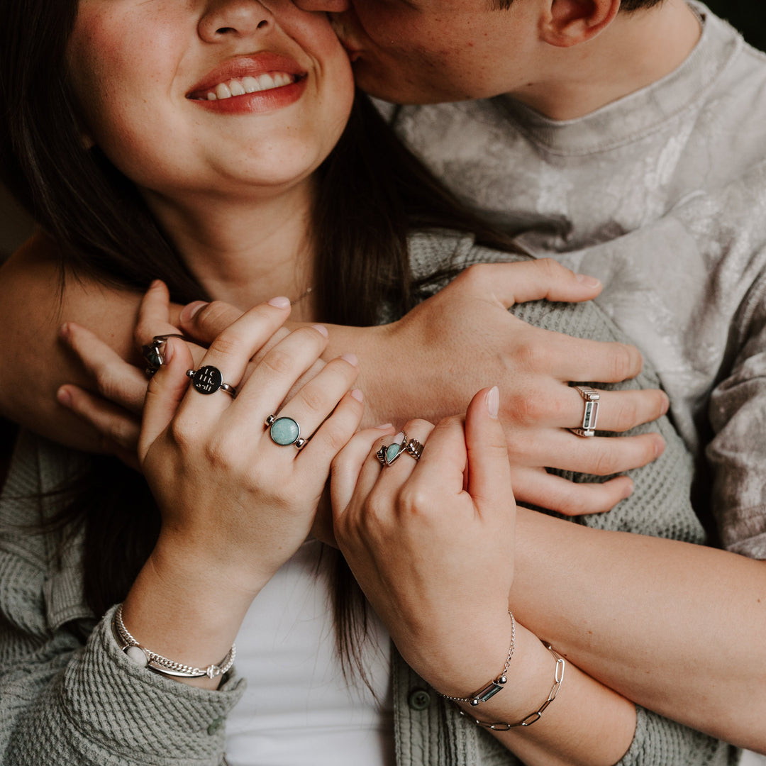 Two people embracing wearing crystal fidget jewelry
