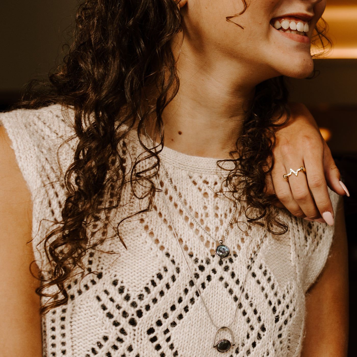 Person smiling and wearing Hematite necklace