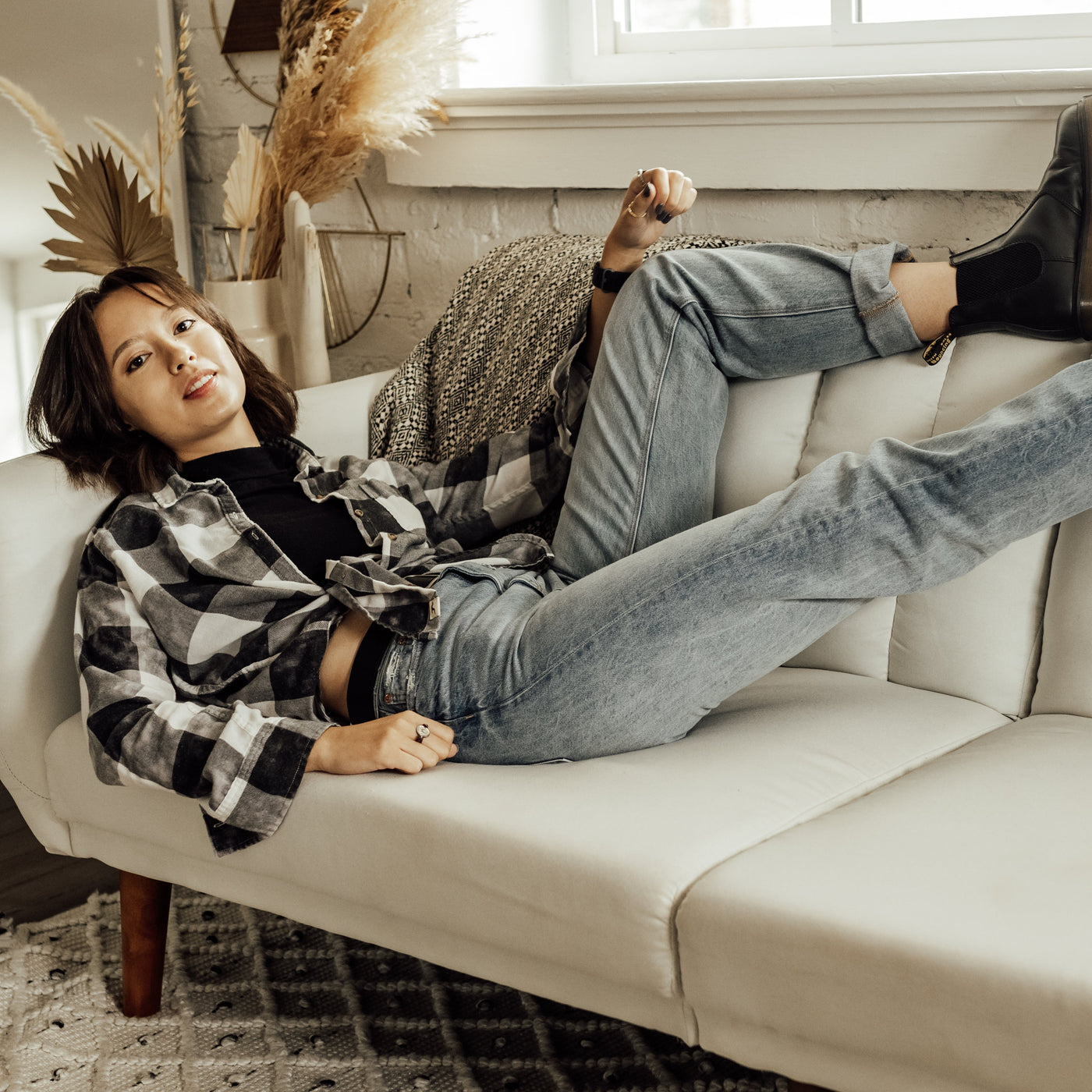 Person laying on a white couch, wearing anxiety rings