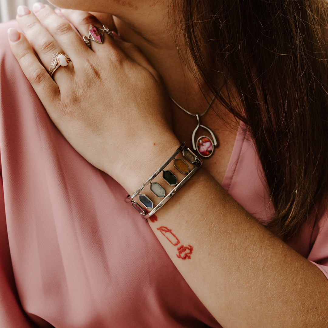 Person showing their custom fidget rings, bracelet, and necklace