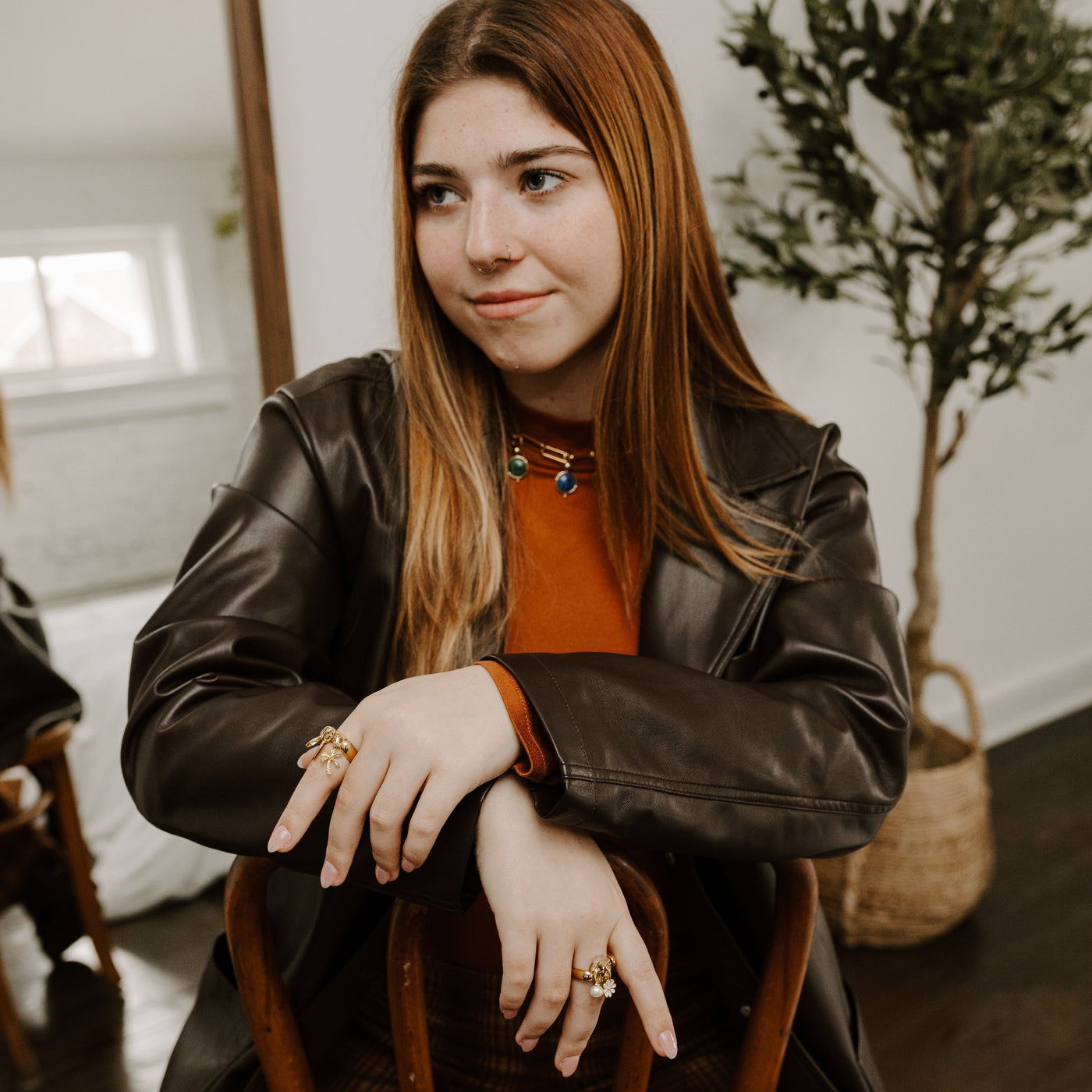 Person sitting on a chair wearing charm jewelry that is also fidget jewelry