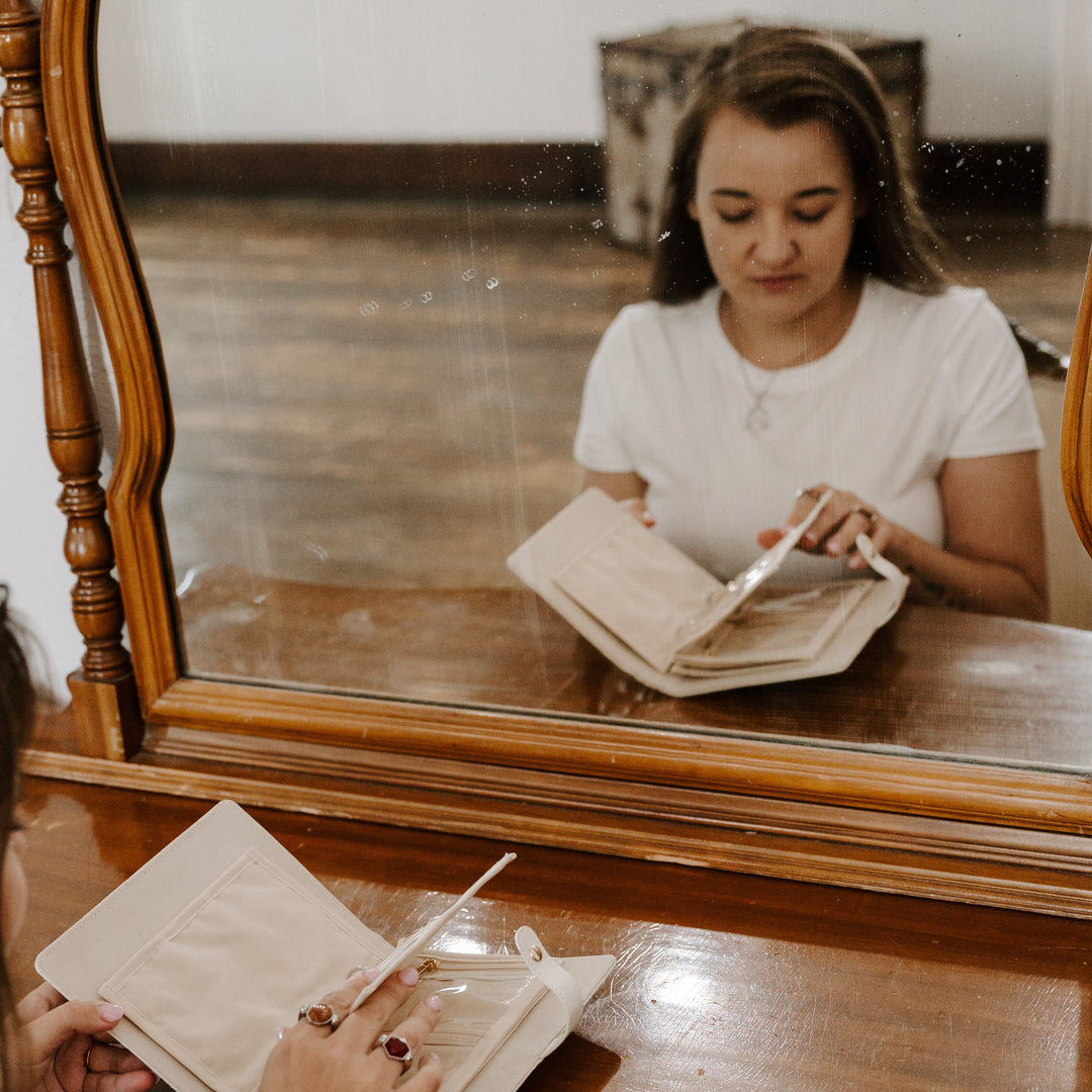 Photograph of the reflection of a person opening up a journal