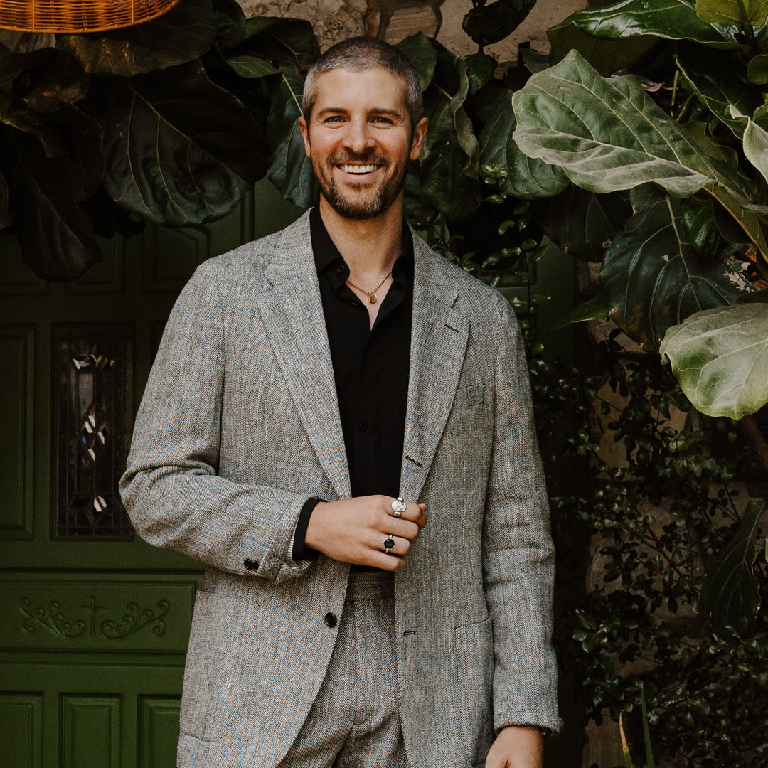 Man posing outside wearing a gray suit and fidget rings