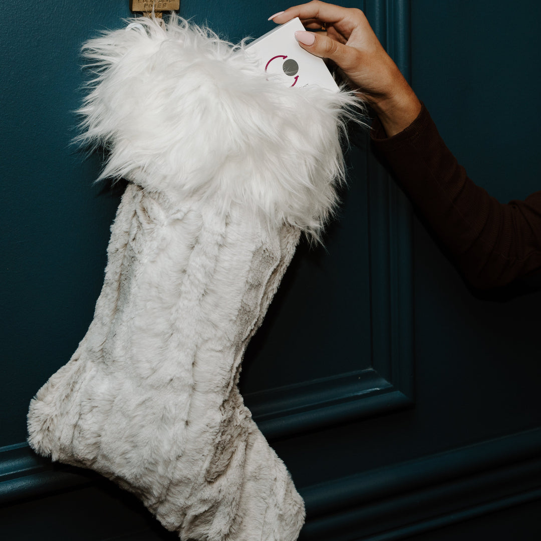 Person putting a fidget jewelry gift in a stocking 