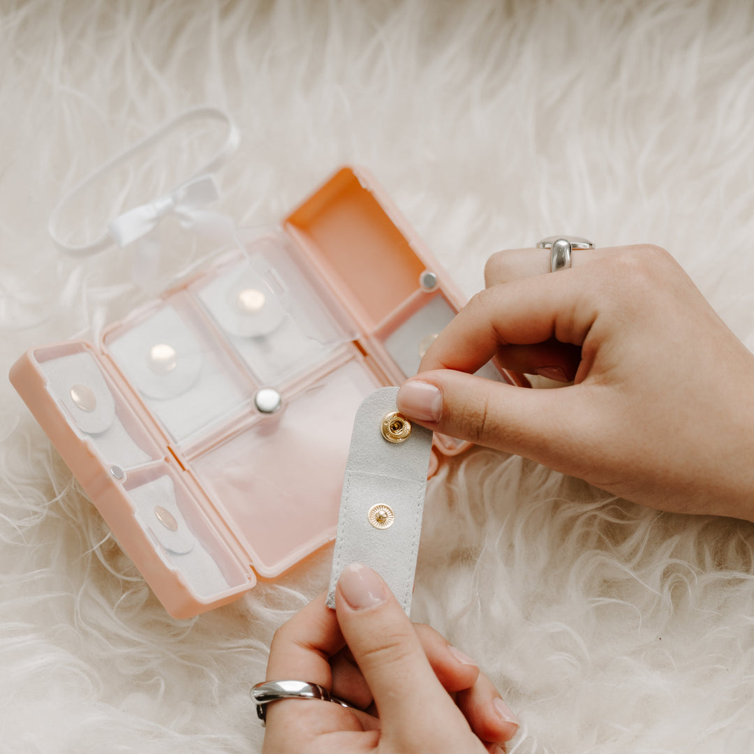 Person organizing fidget jewelry in pink jewelry box