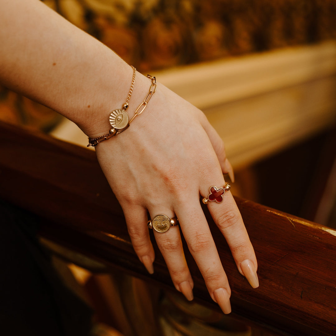 Person holding onto a railing wearing gold fidget jewelry