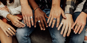 seven hands in various skin tones wearing CONQUERings